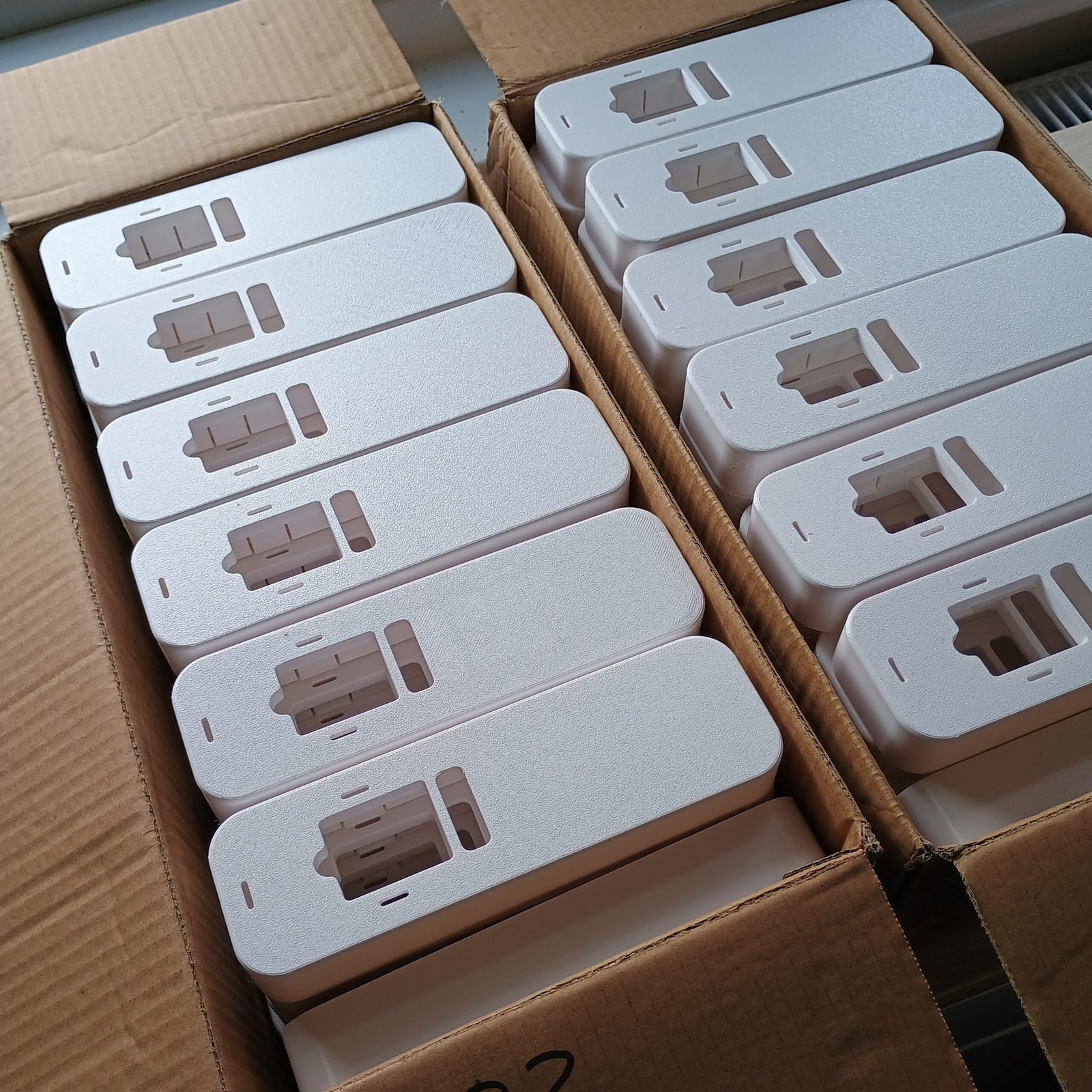 White PETG radiator meter covers arranged in production boxes.